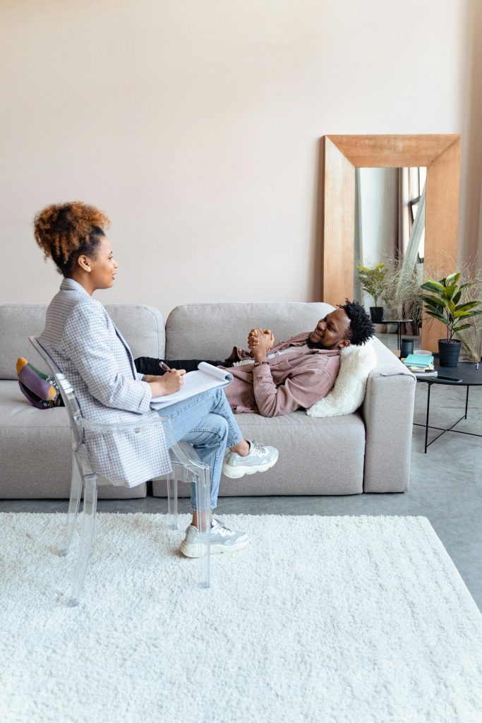 Counselor in a casual conversation with a client lying on the sofa